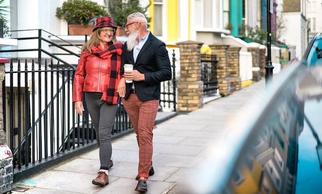 Happy senior couple walking holding hand in Notting Hill in London City