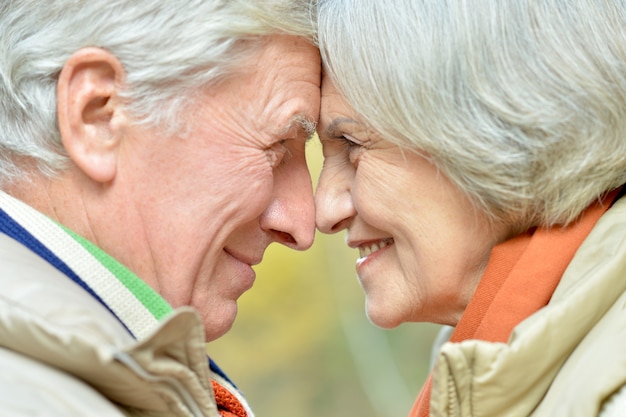 Happy senior couple walking in park close-up