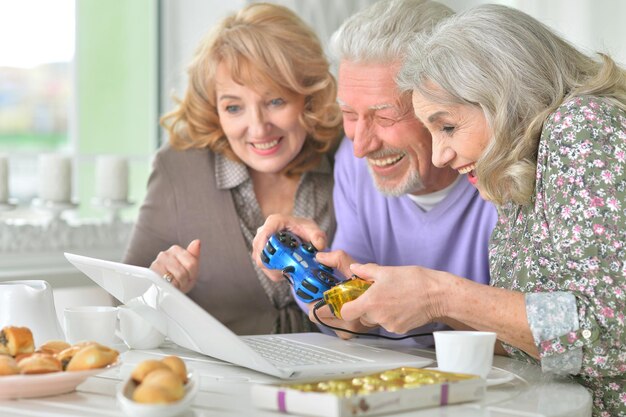 Happy senior people playing computer game