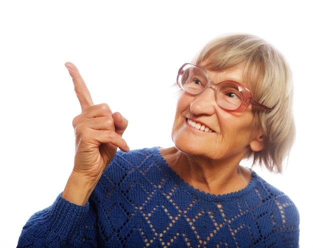 Happy senior woman pointing upwards isolated on white background