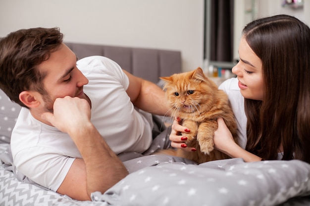 Happy sensual young couple lying in bed together.