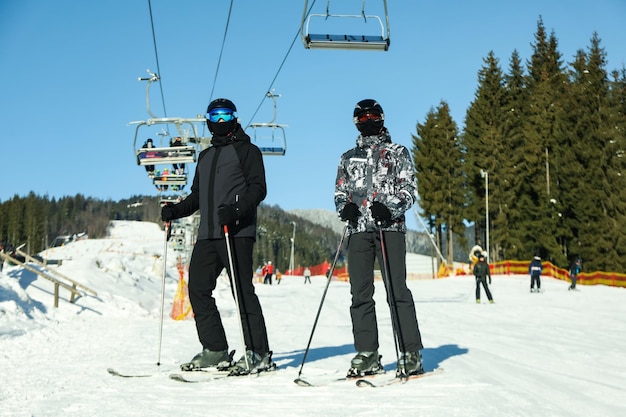 Happy skiers in mountain resort in sunny day