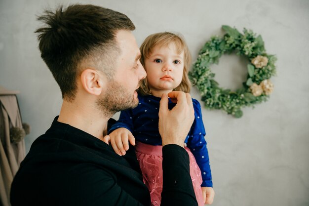 Happy small kid girl enjoying sweet moment with dad in living room