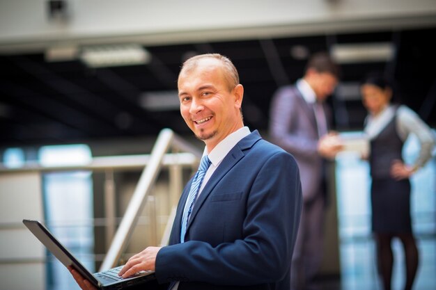 Happy smart businessman with teammates discussing in the background