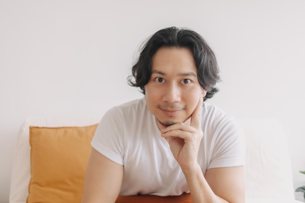 Happy smile face long hair man sit and relax on the sofa in living room