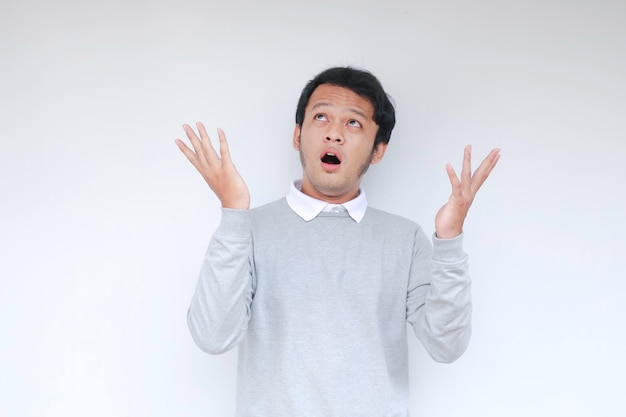 Happy and smile face with smile of young Asian man in white shirt with hand point on above empty space