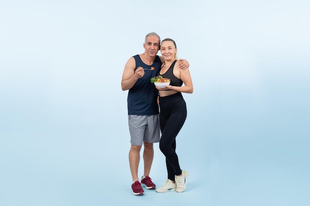 Happy smile senior man and woman portrait holding bowl of vegan fruit and vegetable on isolated background Healthy senior couple with healthy vegetarian nutrition and body care lifestyle Clout