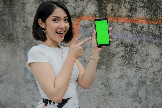 Happy and smile young asian women showing green blank screen