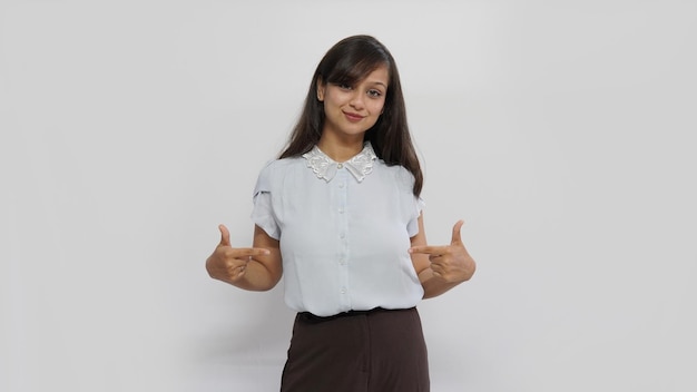 Happy smiling Asian woman pointing with two fingers on her blank dress