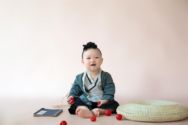 Happy smiling baby holds red fruit in hands