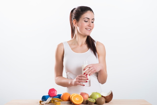 Happy and smiling beautiful young woman enjoying a glass milk