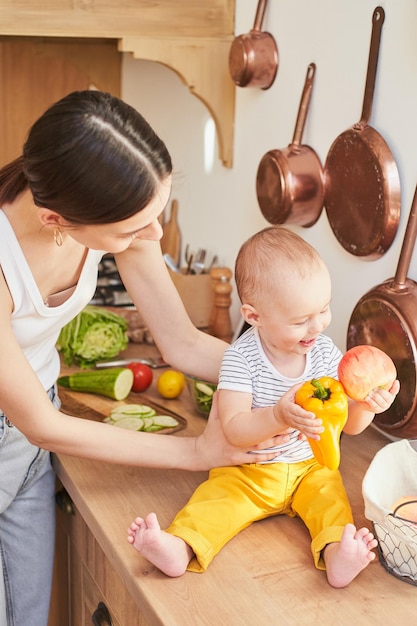 A happy smiling boy with his mother in the kitchen cooking together