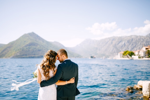 Happy smiling bride and groom embracing on the scene of a beautiful mountain landscape on a