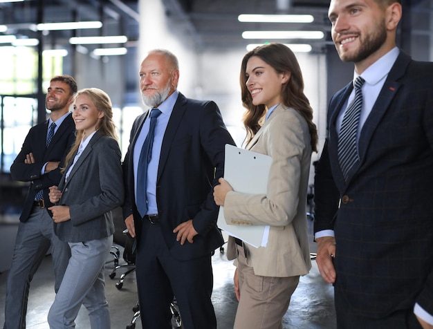 Happy smiling business team standing in a row at office