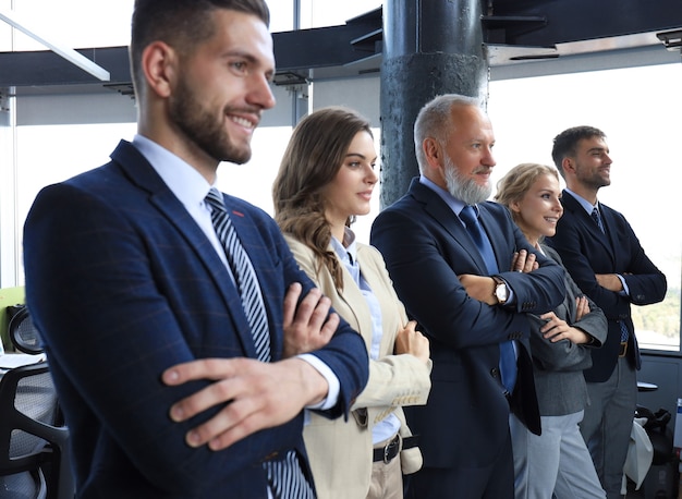 Happy smiling business team standing in a row at office.