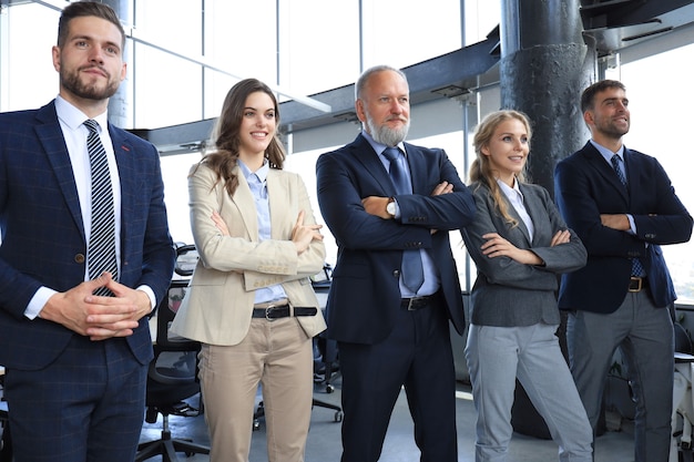 Happy smiling business team standing in a row at office.