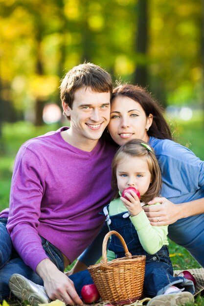 Happy smiling family having picnic in autumn park