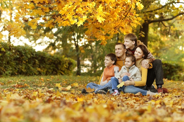 Happy smiling family relaxing in autumn forest