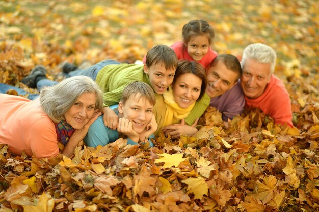 Happy smiling family relaxing in autumn forest