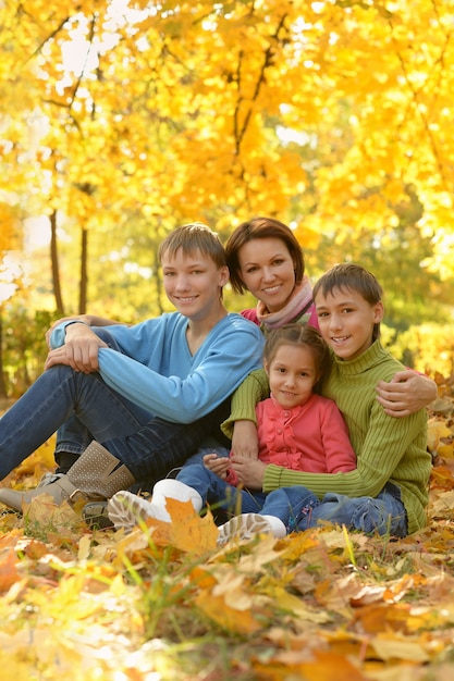 Happy smiling family relaxing in autumn park