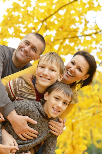 Happy smiling family relaxing in autumn park