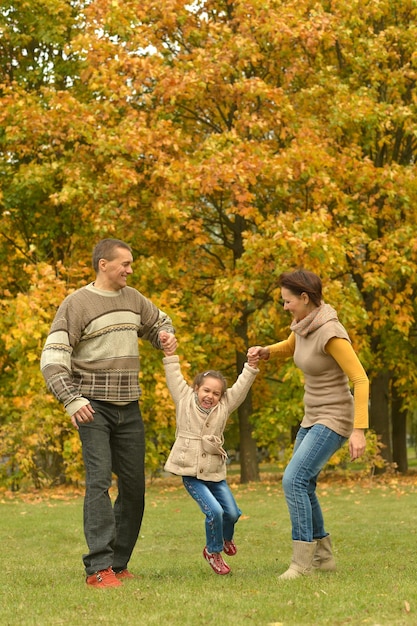 Happy smiling family relaxing in autumn park