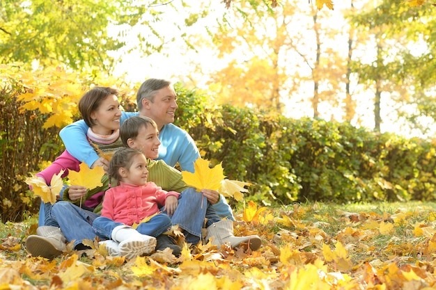 Happy smiling family relaxing in autumn park