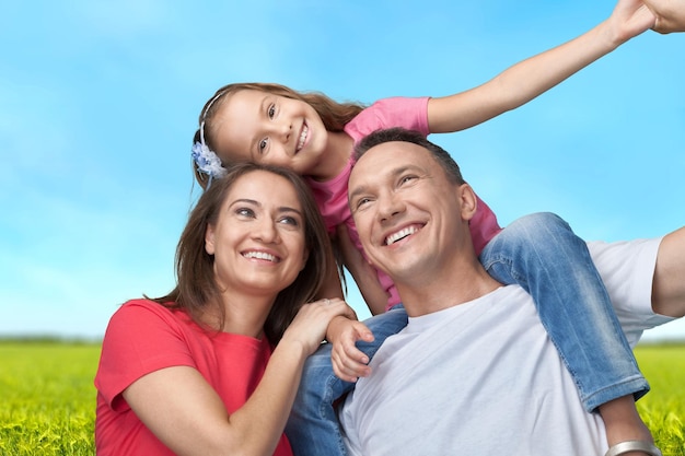 Happy smiling family with daughter on park background