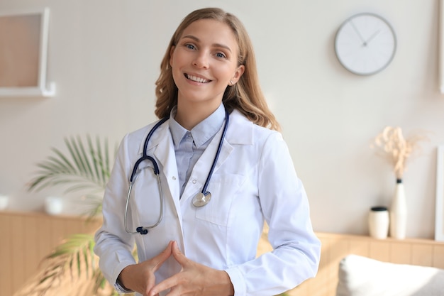 Happy smiling female doctor in white uniform coat and stethoscope.