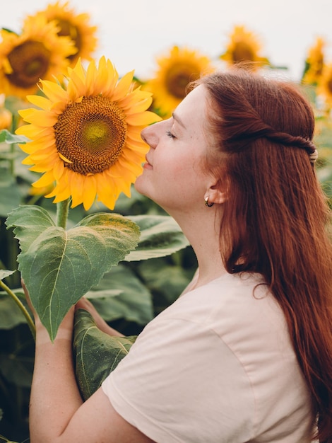 Happy Smiling female standing in sunflowers field on summer day Harvest time Summer vacation