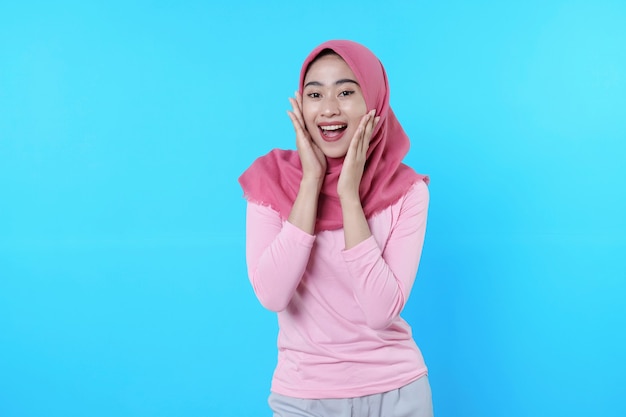 Happy smiling female with attractive appearance and wearing hijab, pink t shirt showing smile good mood