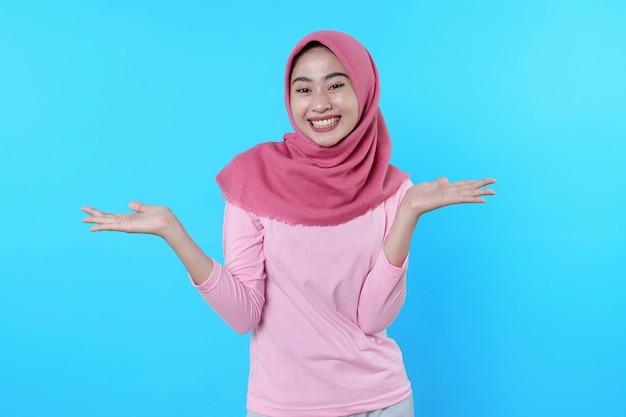 Happy smiling female with attractive appearance and wearing hijab, pink t shirt showing smile good mood