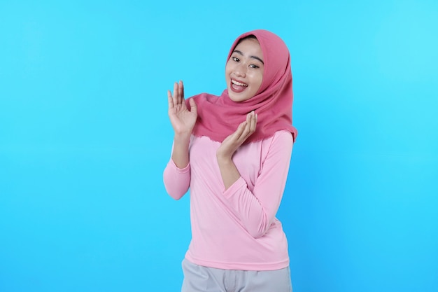 Happy smiling female with attractive appearance and wearing hijab, pink t shirt showing smile good mood