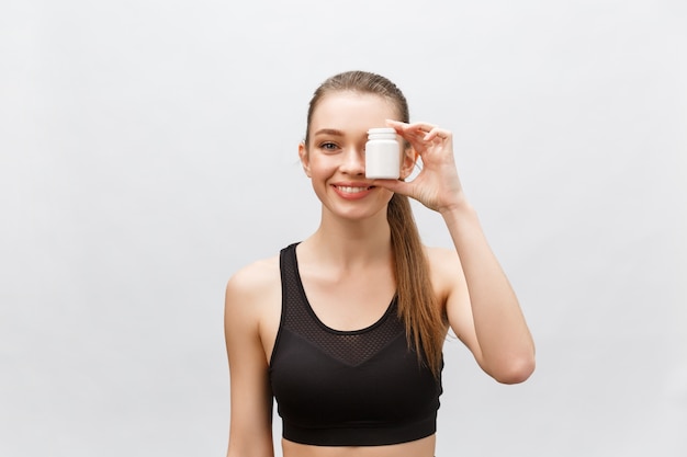 Happy Smiling Girl Holding a supplement bottle.