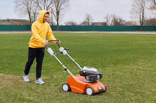 Happy smiling handsome man wearing yellow hoodie and black pants