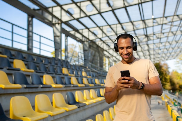 Happy and smiling indian man in park stadium walking after active jogging and fitness classes using