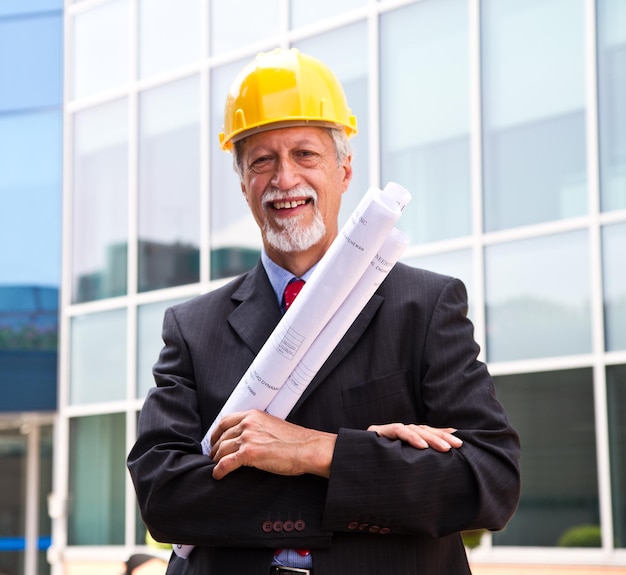 Happy, smiling older architect looking out