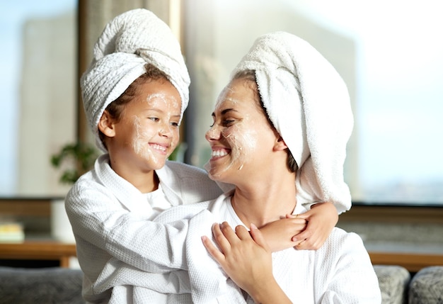 Happy smiling and relaxed mother and daughter spa day at home with face masks for healthy skincare and personal hygiene Cute little girl and parent bonding and enjoying a pamper treatment together