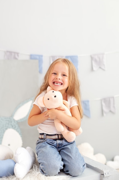 happy smiling toothless little blonde girl. Child smiling without his milk teeth in children room.