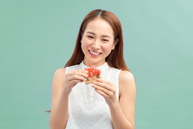 Happy smiling woman holding small red gift box