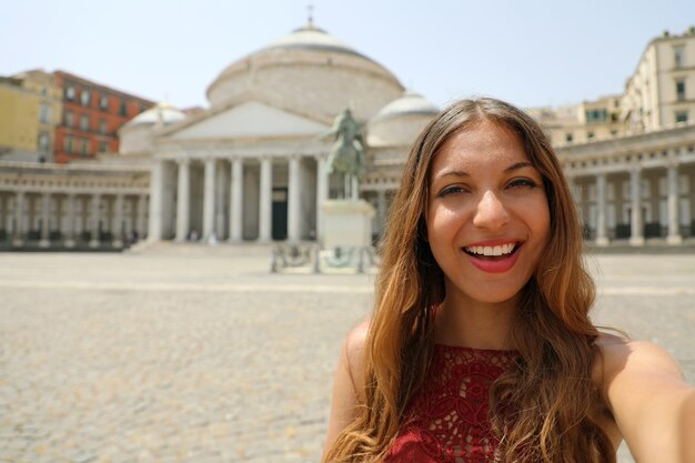 Happy smiling woman in Naples with Piazza del Plebiscito square, Naples in Italy