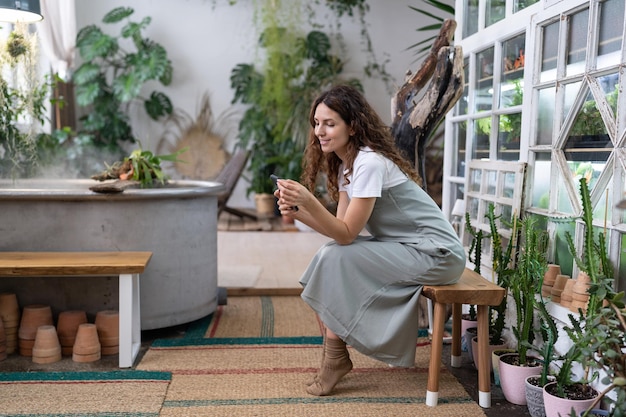 Happy smiling woman relax in home garden using smartphone chatting in social media with friend