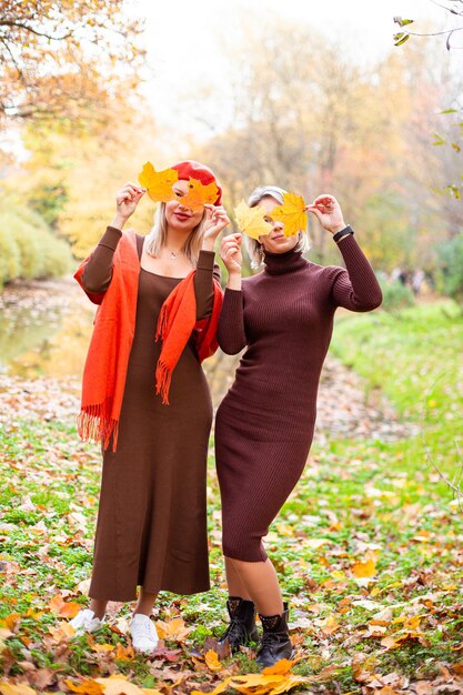 Happy smiling womans holding in her hands yellow maple leaves