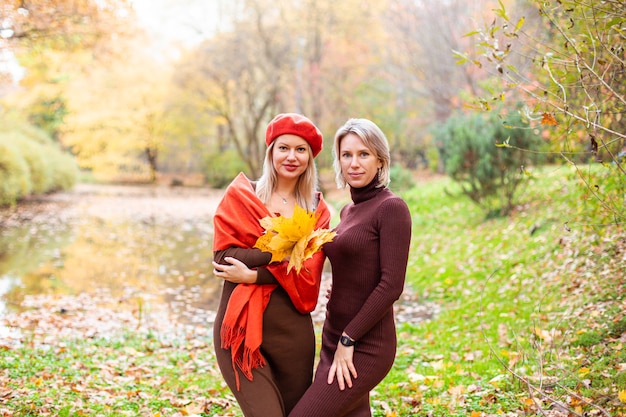 Happy smiling womans holding in her hands yellow maple leaves