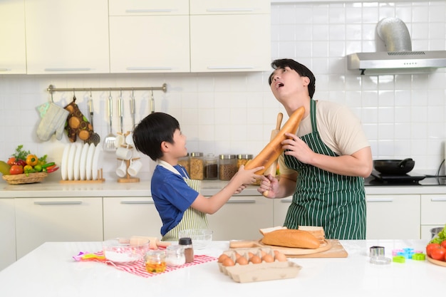 Happy smiling Young Asian father and son cooking in kitchen at home