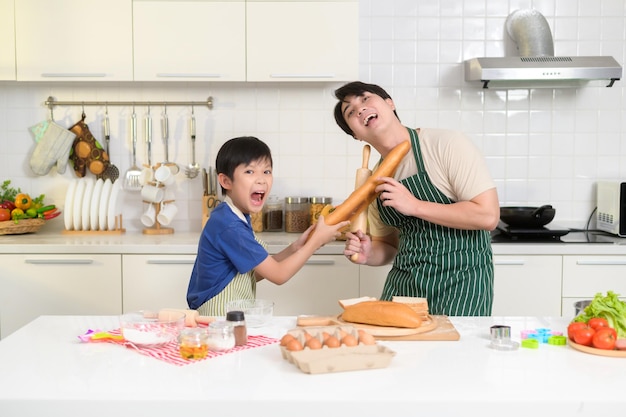 Happy smiling Young Asian father and son cooking in kitchen at home