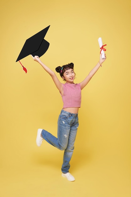 happy smiling young Asian student elementary school girl holding graduation hat and diploma