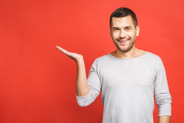 Happy smiling young man presenting and showing