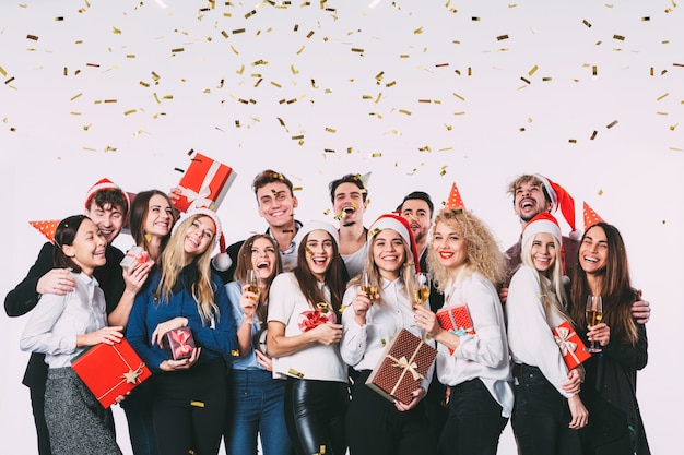 Happy smiling young people with gift boxes and party decorations