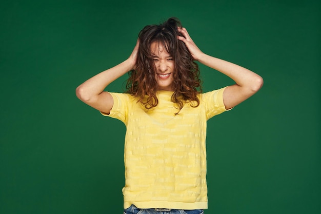 Photo happy smiling young pretty girl ruffle brown curly hairs having fun haircare and styling products